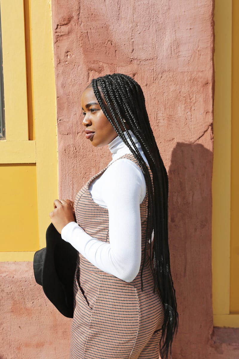 Fashionable woman with braided hair posing confidently outdoors.
